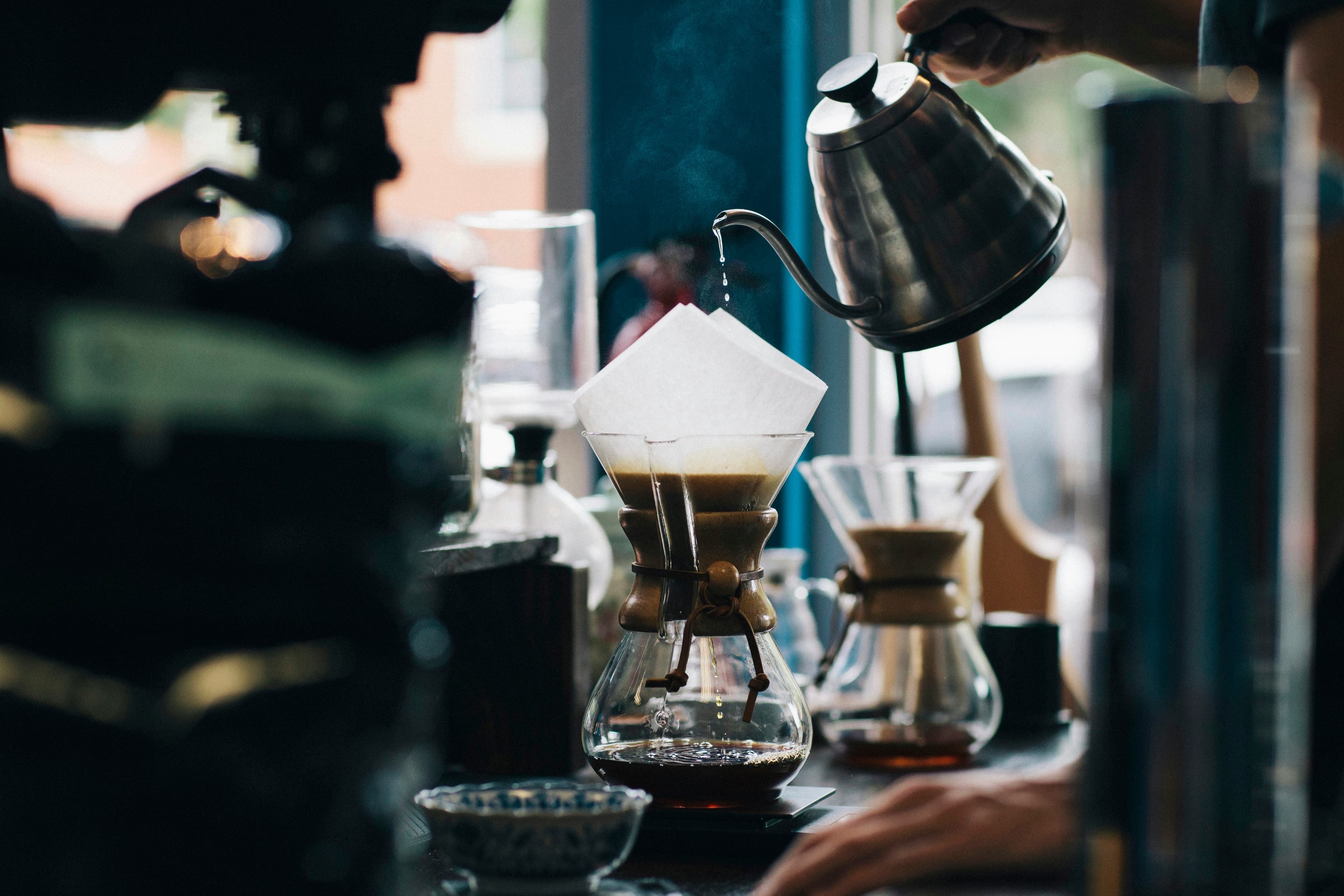 Barista rót nước nóng qua phễu lọc tại quầy pha chế